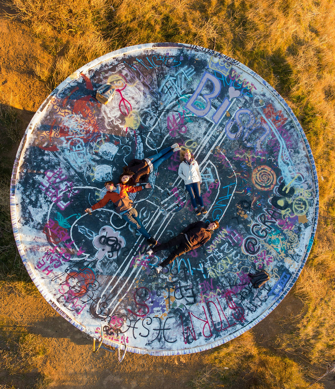 four people laying down in a circle